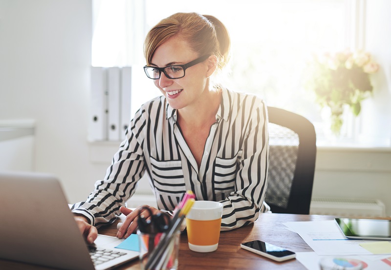 Successful female entrepreneur with a new online business working from home on her computer typing in data